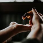 person holding amber glass bottle